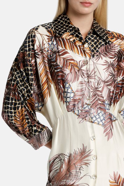 Camicia button-up che presenta un mix di tessuti neri e beige, con vivaci motivi a foglia e un colletto testurizzato. Materiale morbido e leggero.