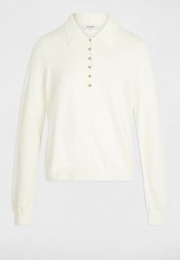 Maglioncino a polo a maniche lunghe di colore crema, realizzato in tessuto morbido, dotato di colletto e un'apertura frontale con bottoni con dettagli dorati.