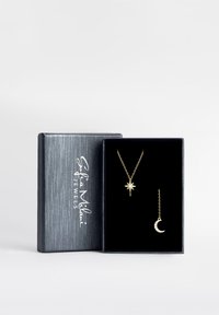 Guld smykke sættet i en sort fløjlsæske; inkluderer en stjerne vedhæng halskæde og en halvmåne ørering. Äsken har en struktureret sølvfarvet overflade.