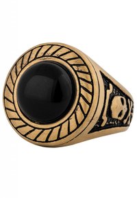 Anello in metallo dorato con un grande centro in pietra nera, caratterizzato da una fascia testurizzata con dettagli intagliati di teschi e ossa incrociate.