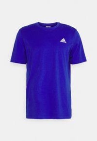 Sininen lyhythihainen T-paita, joka on valmistettu puuvillasta. Paidassa on pyöreä kaula-aukko ja pieni valkoinen Adidas-logo rinnan kohdalla. Pehmeä rakenne.