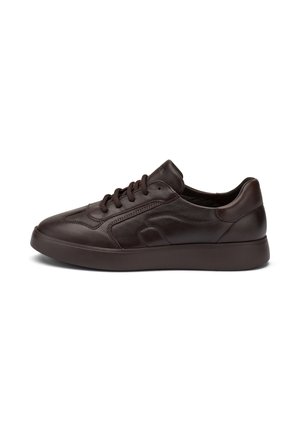 Zapatillas de cuero marrón con una textura suave, punta redondeada y cordones tonales. Presentan una suela de goma de perfil bajo y detalles de costura mínimos.