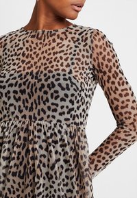 Leopardenmuster-Kleid mit langen transparenten Ärmeln, rundem Ausschnitt, halbtransparentem Stoff und gerafften Rockdetails in Braun- und Beigetönen.