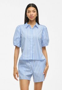 Camicia azzurra a righe con maniche corte e colletto, maniche a sbuffo e pantaloni coordinati, caratterizzata da un tessuto morbido e una vestibilità comoda.