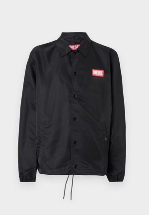 Must must, misasest kergest ja siledast materjalist, nupuvälinge, elastsete mansettide, küljetaskute ning punase Diesel logo plaastriga.