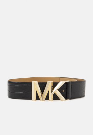 Ceinture en cuir noir effet crocodile avec grande boucle métallique dorée affichant les lettres M et K.