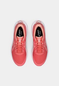 Baskets de sport roses avec une tige en maille respirante, un design à lacets, une semelle rembourrée et une semelle en caoutchouc. Présente un logo sur la languette et les côtés.
