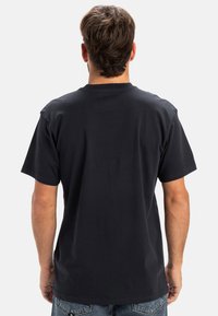 Sort bomulds t-shirt med korte ærmer, rund halsudskæring og en afslappet pasform. Synlig syning på skuldre og kant. Simpelt design uden mønstre.