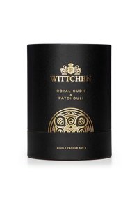 Contenitore cilindrico nero per candele con scritte dorate. Le etichette riportano "WITTCHEN," "ROYAL OUDH & PATCHOULI," e "CANDELA SINGOLA 460 g." Finitura testurizzata.