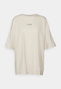 Camiseta corta de manga corta en color crema, con un corte holgado, cuello redondo y la palabra "VENUS" estampada en el centro. Tejido de algodón suave.