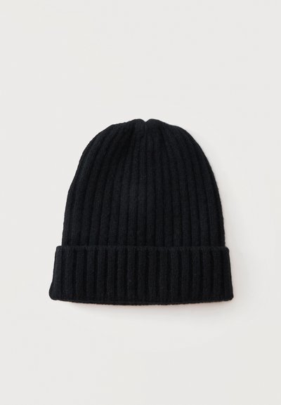 Bonnet en maille côtelée noire avec revers plié, présenté sur un fond clair uni.