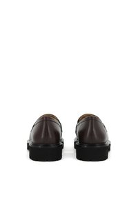 Scarpe in pelle bordeaux scuro con punta arrotondata, texture liscia, profilo basso e suola spessa in gomma nera. Presentano cuciture lungo i bordi.