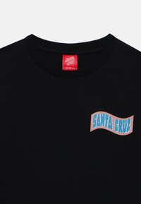 Czarna bawełniana koszulka z kolorowym logo "SANTA CRUZ" na lewej piersi, z okrągłym dekoltem i krótkimi rękawami.
