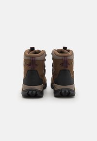 Bruine wandelboots hebben een bovenwerk van leer en mesh, een gewatteerde schacht, en een rubberen buitenzool met noppen voor grip. Achterlussen voor eenvoudig aan- en uittrekken.