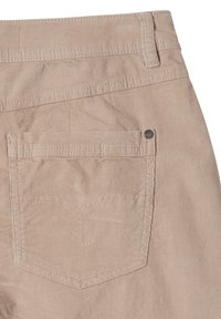 Beżowa tkanina kordurowa z tylną kieszenią z wytłaczanym wzorem. Kieszeń obszyta jest kontrastującymi stębnowaniami oraz metalowym nitom.