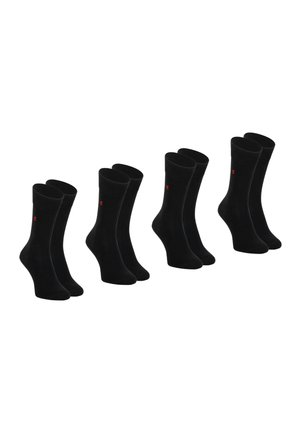 Quatre paires de chaussettes noires montantes avec un petit logo rouge sur le côté, présentées debout sur un fond blanc.