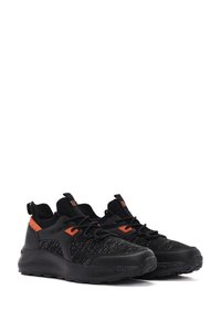 Baskets de sport noires avec un tissu texturé, des accents orange et une semelle rembourrée. Équipées de lacets et d'un design à soutien de la cheville élevé.