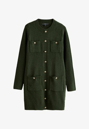 Grön stickad kofta med rund halsringning, ribbade ärmar, två påsydda fickor och dekorativa knappar fram.