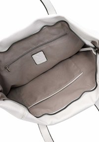 Balta odinė rankinė su minkštu smėlio spalvos audiniu viduje, įskaitant užtrauktuką ir papildomą kišenėlę. Juodas užtrauktukas.