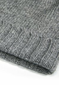 Gray knitted wool fabric with ribbed texture, featuring a soft, fuzzy surface and folded edge, showcasing a uniform color throughout.
