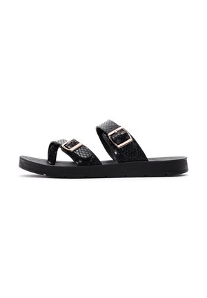 Chanclas negras de material texturizado, con dos hebillas de tono dorado y suela plana de goma.