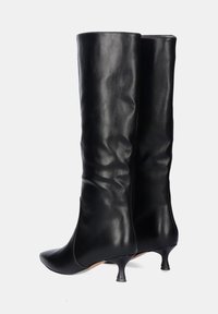 Botas negras de cuero hasta la rodilla con punta afilada, que presentan un diseño elegante y un exclusivo tacón de gato, textura suave y detalles mínimos.