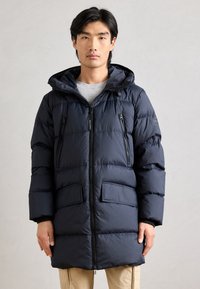 Tengerészkék puffacipzáros kabát kapucnival, elöl két zsebbel és sima, steppelt textúrával. Könnyű és szigetelt.