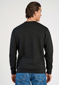 Felpa nera con colletto a giro, polsini e orlo a coste. Texture liscia, design semplice e senza visibile branding o motivi.
