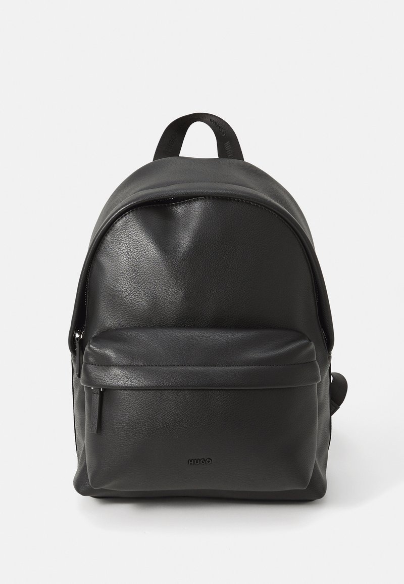 Zaino in pelle nera con tasca frontale con zip, manico superiore e logo "HUGO" sul taschino frontale, su sfondo bianco.