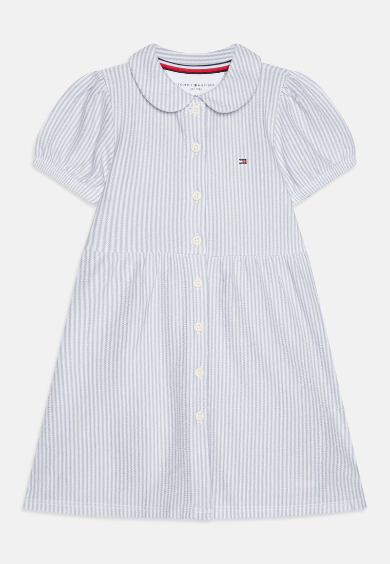 Světle modré pruhované bavlněné šaty s krátkými puff rukávy, límečkovým výstřihem a předními knoflíky. Na hrudi se nachází malé logo.