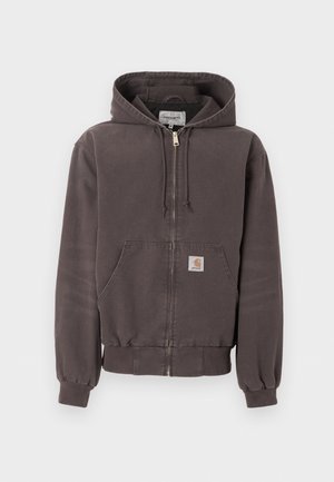 Tamsiai pilkas užsegamas bliuzonas su priekinėmis kišenėmis, raištelio tipo gaubtu, ribotais rankogaliais ir apačia bei mažu logotipo lopu kišenėje.