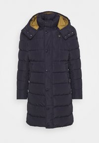 Marinblå puffjacka med guldinteriör, utrustad med avtagbar huva, stora knappar och quiltade sektioner för extra isolering.