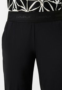 Schwarze Hose mit elastischem Bund und strukturiertem Logo-Band, aus glattem, leichtem Stoff und in taillierter Passform.