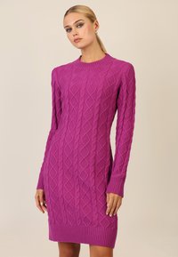 Fuchsia gebreide jurk met lange mouwen, versierd met ruit- en kabelpatronen, met ribgebreide manchetten en zoom. Zachte textuur, aansluitende silhouet.