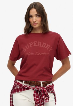 Bordeaux katoenen t-shirt met korte mouwen met de tekst "SUPERDAY Athletic Essentials", gecombineerd met een geruit overhemd dat om de taille is geknoopt.