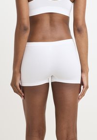 Vita bomullsblandning pojkshorts med en slät textur, som har ett brett elastiskt midjeband och en figurnära design, som visar bakvyn.