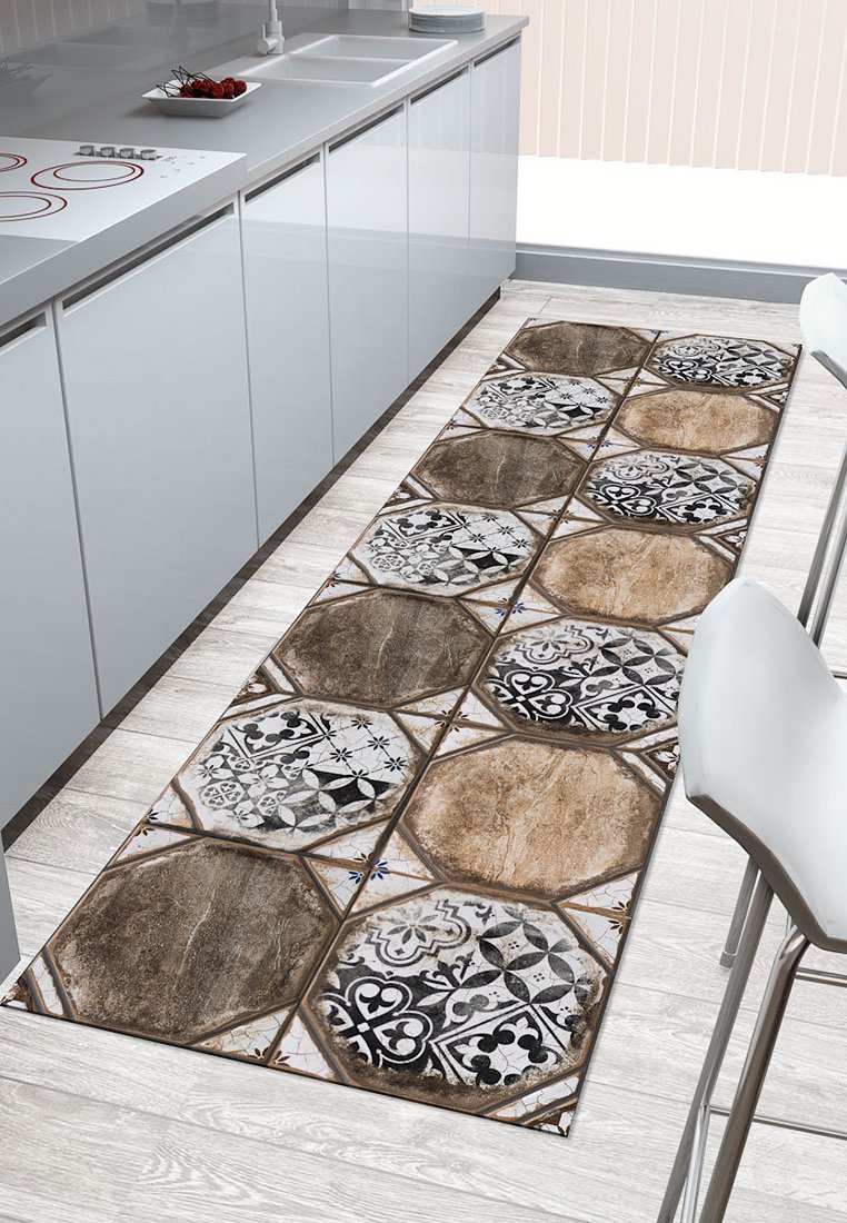 Prostokątny dywan kuchenny z ośmiokątnymi kafelkami w brązowych, kremowych i czarnych wzorach. Fakturowana powierzchnia, ułożony na jasnej drewnianej podłodze.
