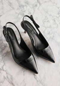 Melnas slingback augstpapēžu kurpes ar smailu purngalu, mākslīgas krokodilu ādas tekstūru, elegantu ādu un mazu papēdi; detaļu loku akcents uz siksniņas.