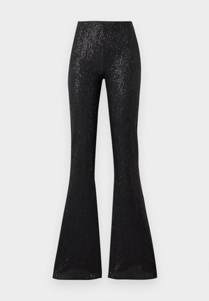 Pantalons évasés noirs en tissu texturé et légèrement brillant, ornés de rayures verticales. La taille est élastiquée, ce qui améliore le confort et l'ajustement.