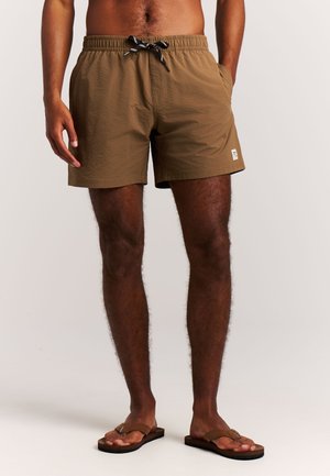 Shorts de bain marron en tissu texturé, dotés d'une ceinture élastique avec cordon de serrage et de poches latérales. Marquage minimal sur l'ourlet.