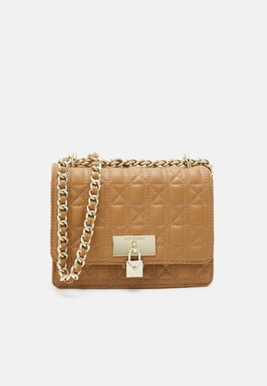 Kleine lichtbruine doorgestikte leren crossbodytas met gouden kettingriem en rechthoekig gouden slot op de voorklep.