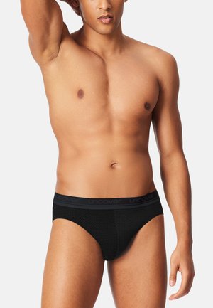 Schwarze Slip-Unterwäsche aus strukturiertem Stoff mit einem weichen Bund, auf dem die Marke "UNCOVER" in einem dezenten Muster abgebildet ist. Glattes, tailliertes Design.