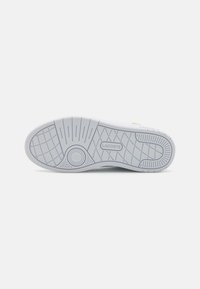 Suola di sneaker bianca con un motivo di battistrada testurizzato, un design circolare nella zona dell'arco e un marchio in rilievo con dettagli raffinati.