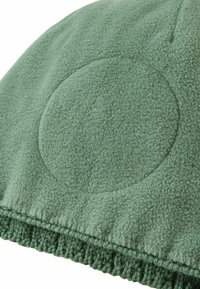 Cappello di pile di colore verde morbido con un dettaglio testurizzato circolare. La parte inferiore presenta un bordo lavorato a maglia per un ulteriore calore e contrasto di texture.