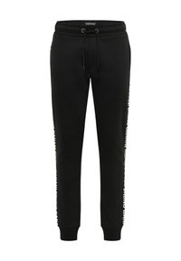 Schwarze Jogginghosen mit Kordelzugbund und weißen Markentexten, die entlang beider Außenbeine verlaufen.