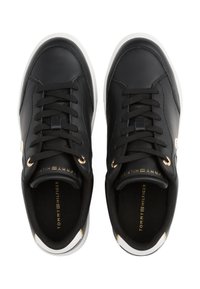 Fekete bőrbakancsok kerek orral, aranyszínű fémfülekkel, fekete fűzőkkel és fehér gumitalppal. A márkajelzés dombornyomott az talpbetéten.