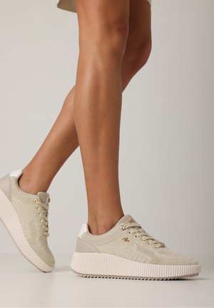 Beige Strick-Sneaker mit strukturiertem Finish, weißen Akzenten und einer dicken geriffelten Sohle. Verfügt über Schnürsenkel und minimalen goldenen Beschlägen.
