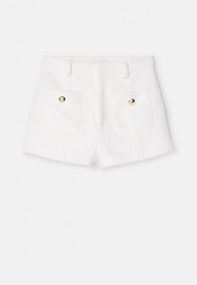 Shorts en tweed blanc avec une surface texturée, présentant deux poches avant et des accents de boutons dorés. Coupé court avec une taille ajustée.