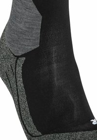 Schwarze und graue Socke mit einem eleganten Design, strukturiertem Stoff und einer gepolsterten Sohle. Die grauen Abschnitte haben ein meliertes Muster.