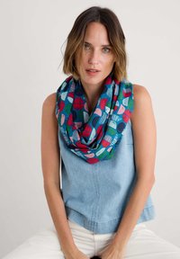 Bufanda circular en azul con un patrón de formas coloridas en rojo, verde y rosa, fabricada con un tejido suave y de textura lisa.
